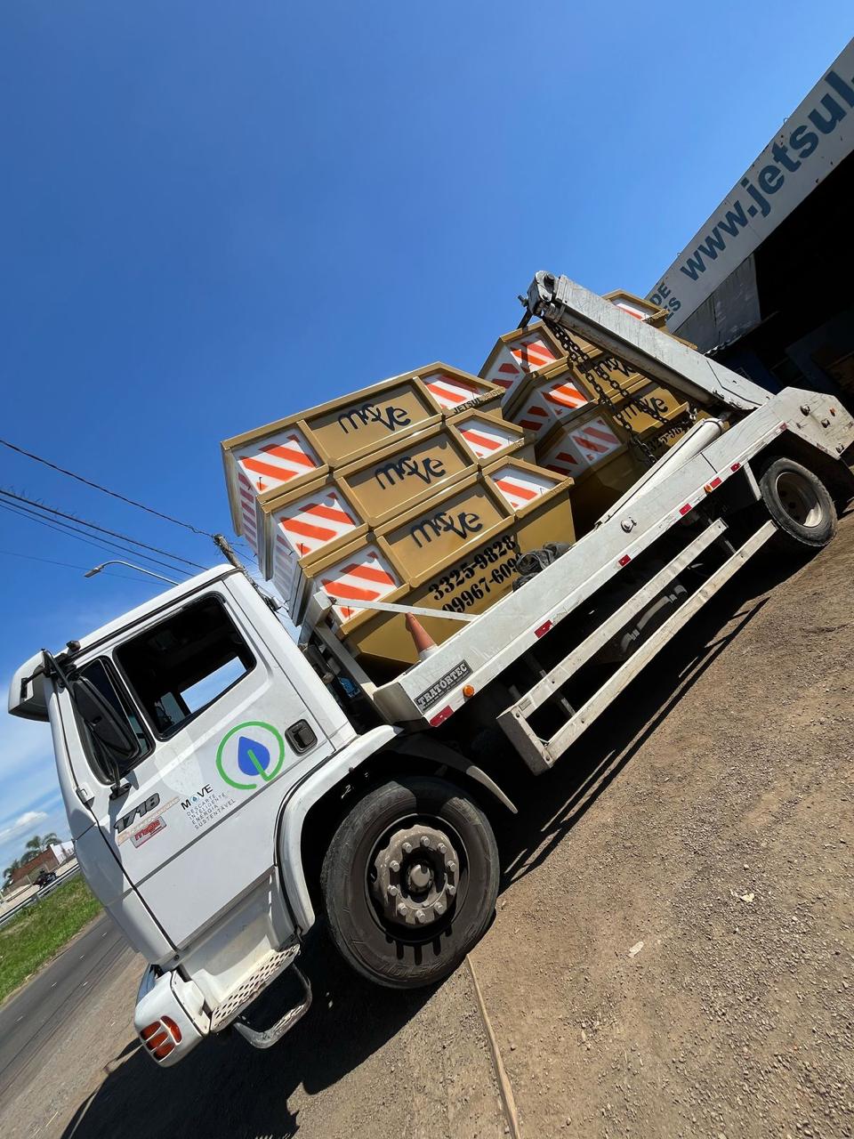 Caminhão da Move carregado de caçambas, pronto para operação.